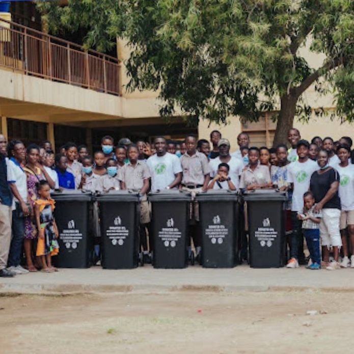 Students and teachers standing behind new waste sorting bins at a school